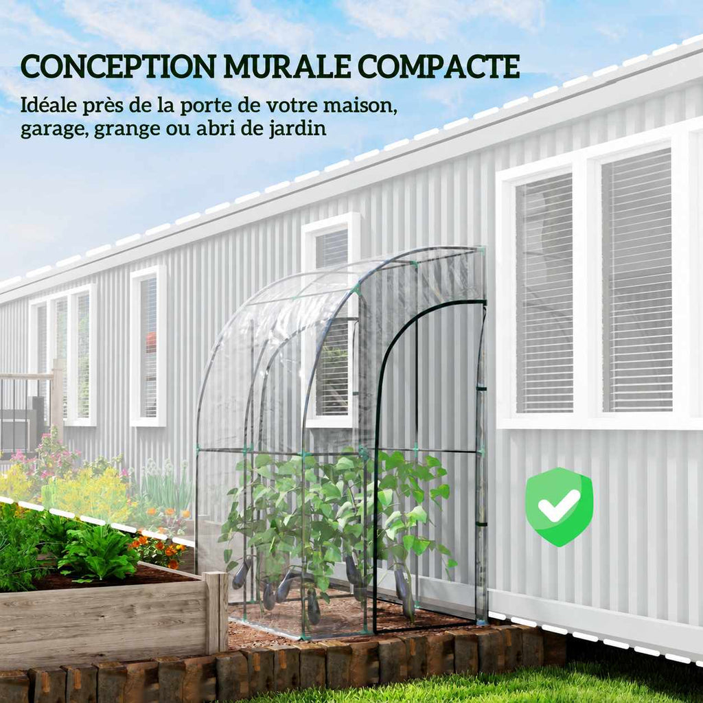 Serre adossée transparente contenant des cultures contre une maison