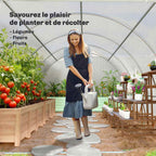 Personne arrosant des plantes à l’intérieur de la serre tunnel blanche