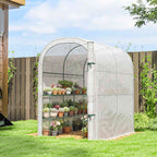 Serre blanche arrondie remplie de plantes en pots dans le jardin