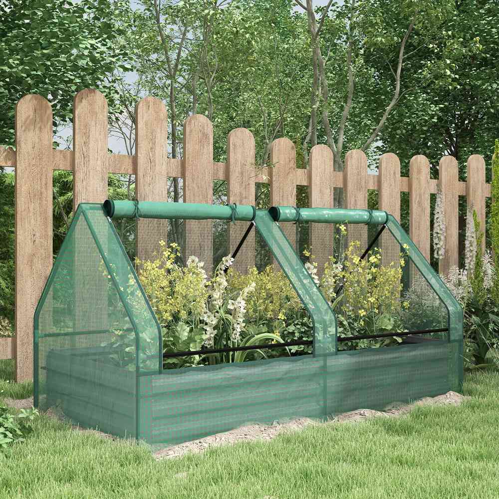 Bac potager couvert vert avec fleurs près d’une clôture