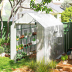 Serre blanche avec plantes sous un arbre au jardin