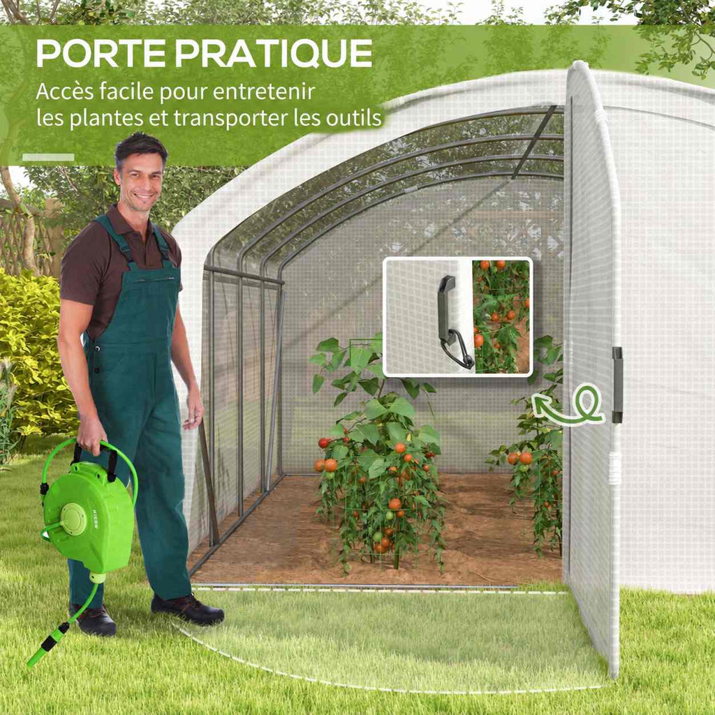 Jardinier avec arrosoir devant la serre blanche ouverte