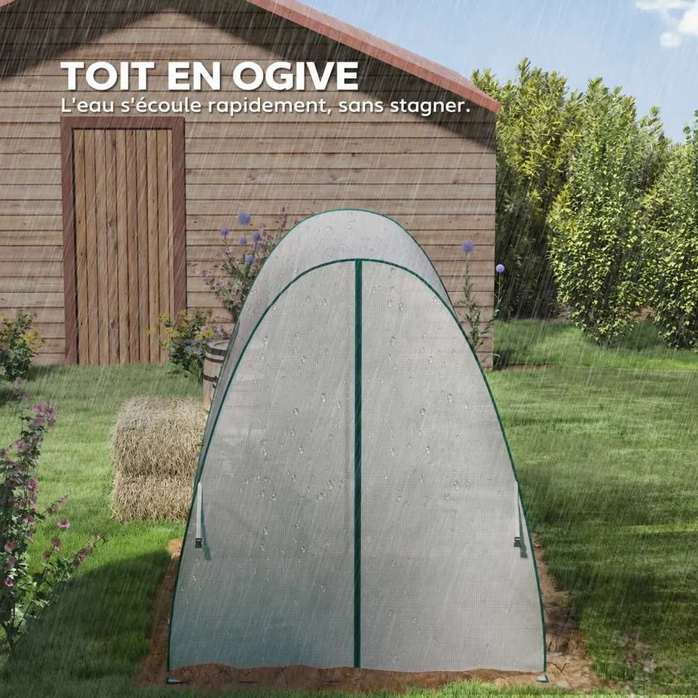Serre blanche ogivale fermée devant un abri de jardin