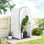 Petite serre blanche contenant une grande plante en pot dans le jardin