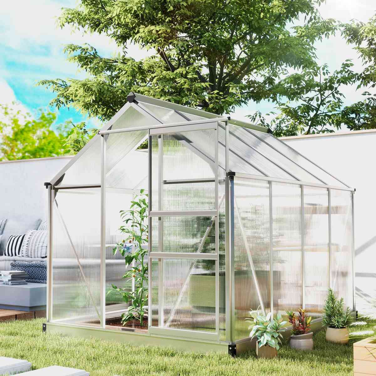Serre argentée avec porte ouverte et plantes dans le jardin