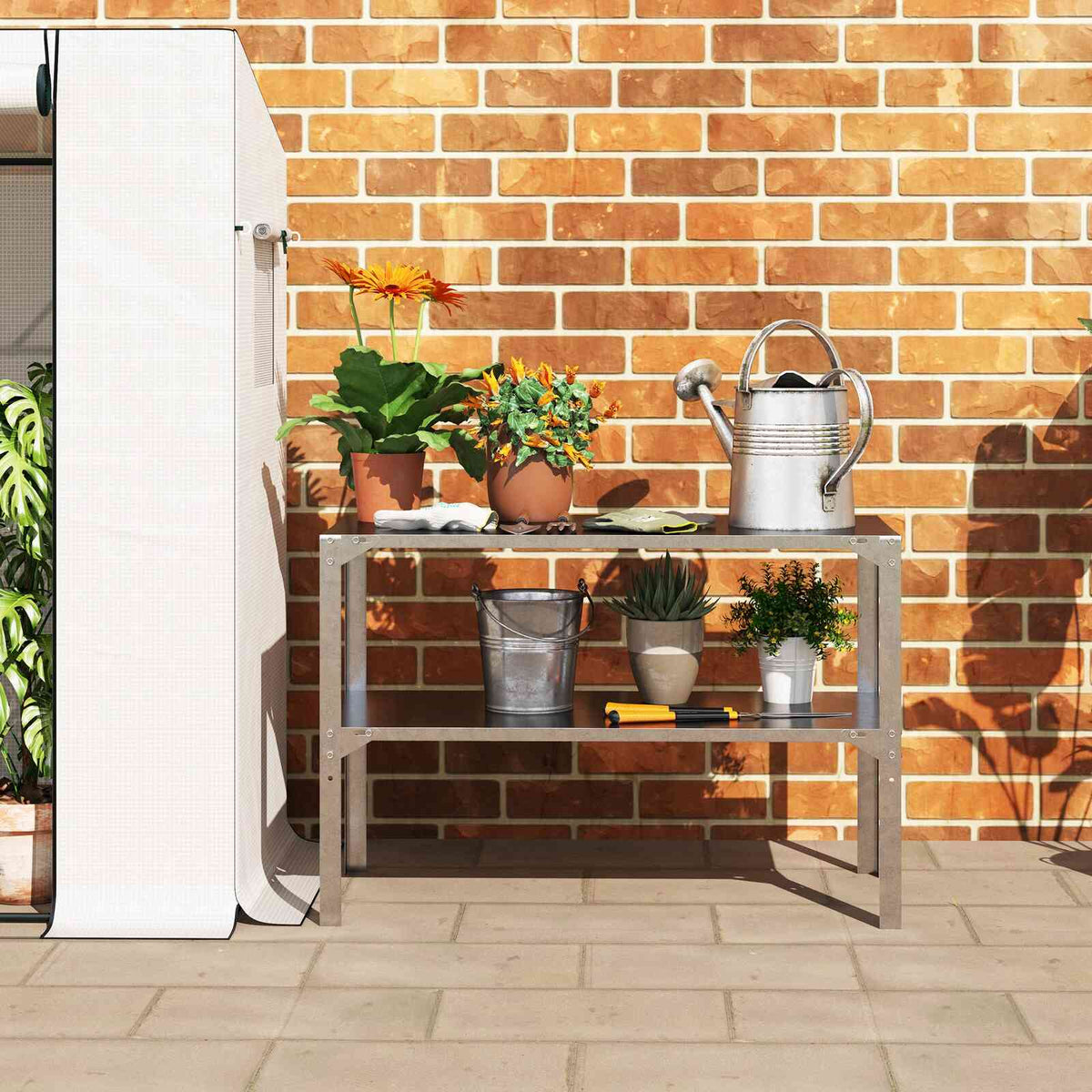 Table de rempotage garnie de plantes et d’un arrosoir contre un mur en briques