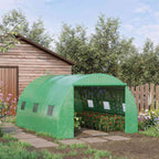 Serre tunnel verte dans un jardin avec cultures visibles par la porte