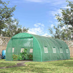 Serre tunnel verte au jardin, plantes visibles par l’entrée