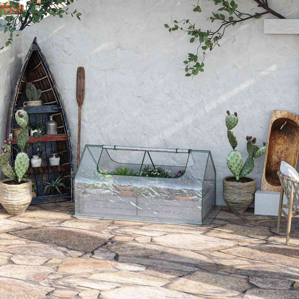 Bac potager avec serre transparente près d’un mur blanc