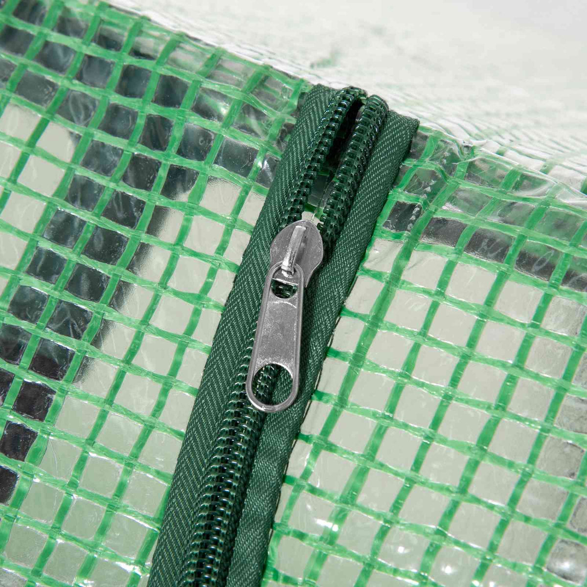 Fermeture zippée sur la bâche verte tramée de la mini-serre
