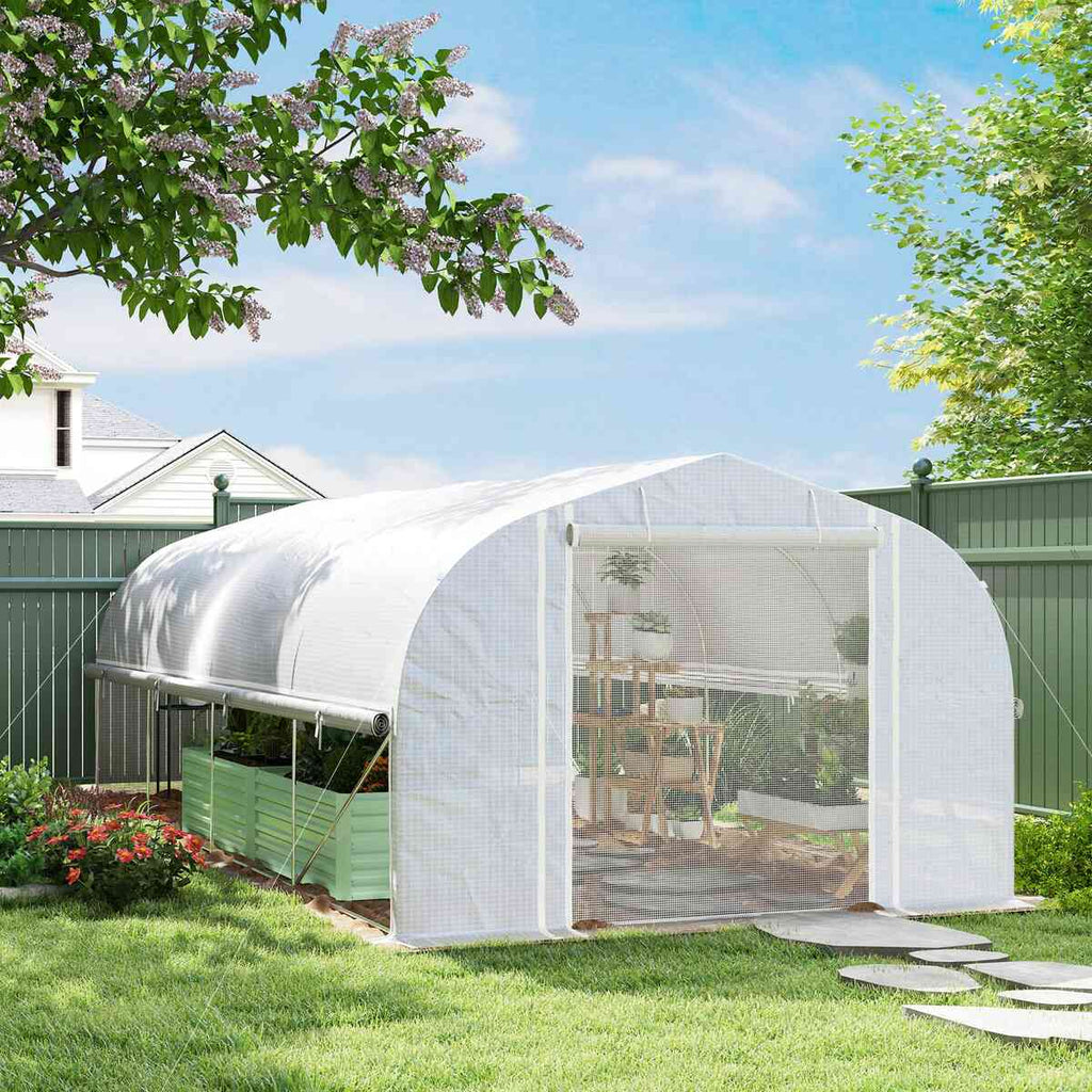 Grande serre tunnel blanche installée dans un jardin