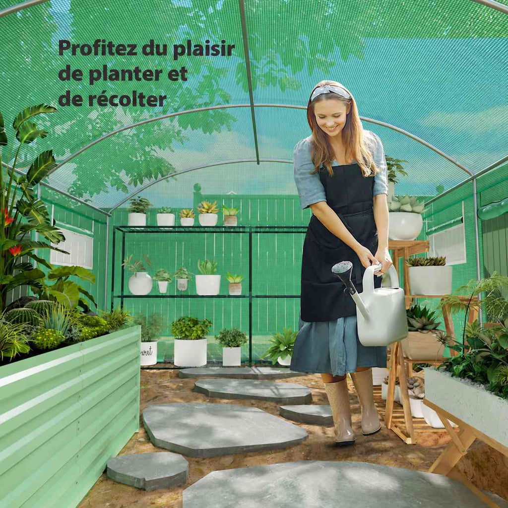 Femme arrosant des plantes dans la serre tunnel verte