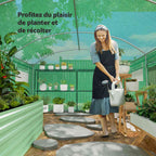 Femme arrosant des plantes dans la serre tunnel verte