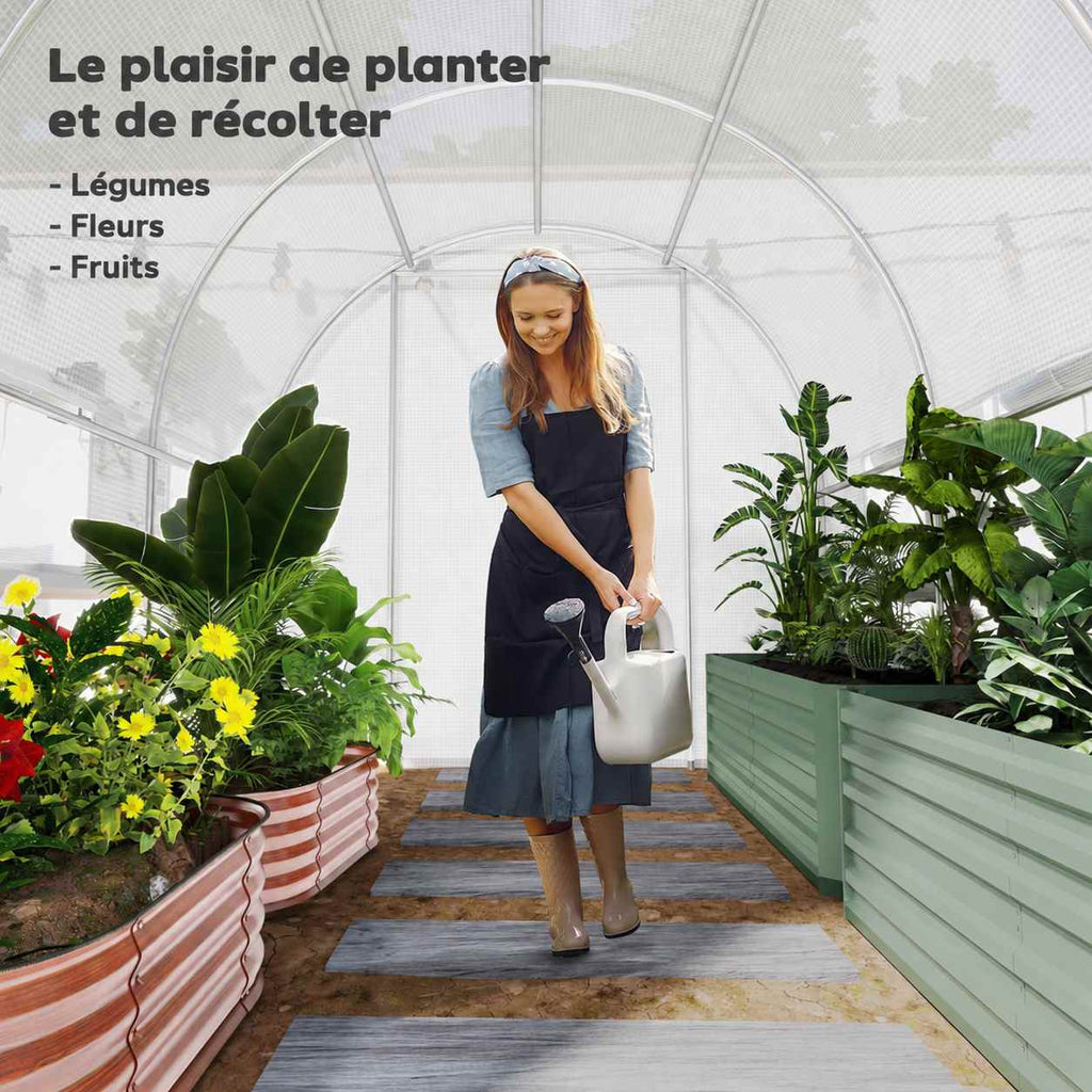 Jardinière arrosant des plantes à l’intérieur de la serre