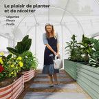 Jardinière arrosant des plantes à l’intérieur de la serre