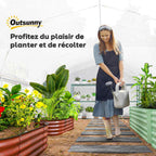 Femme arrosant des plantes dans une grande serre tunnel blanche
