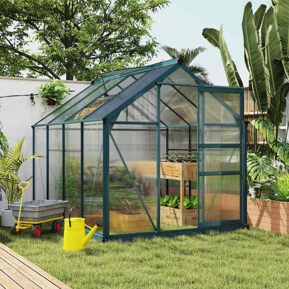 Serre vert foncé au jardin avec plantes et table de culture