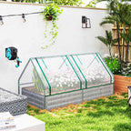 Bac potager argenté avec housse de serre et fleurs contre un mur blanc