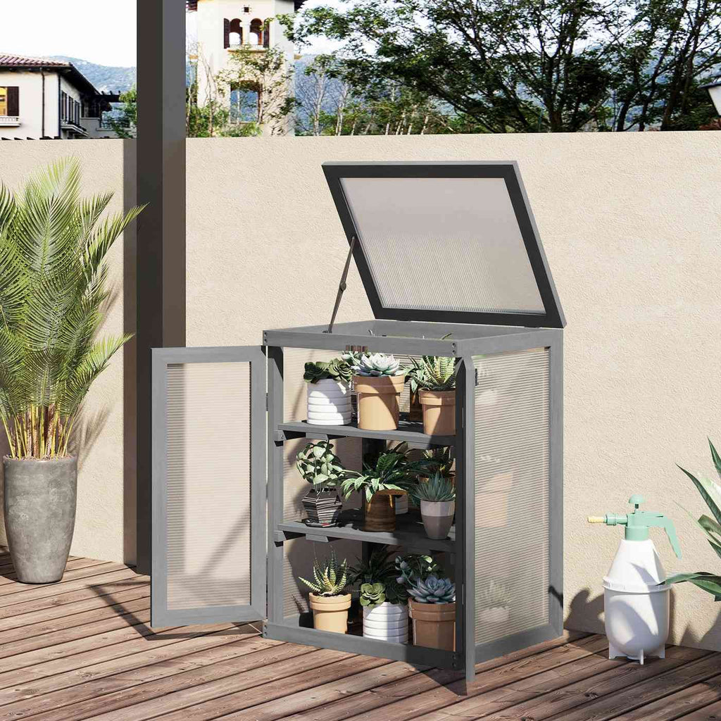 Serre armoire grise ouverte avec plantes en pots sur une terrasse