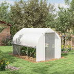 Serre blanche avec côtés enroulés et cultures au jardin