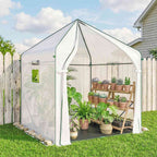 Serre blanche à porte ouverte avec plantes en pots sur une pelouse