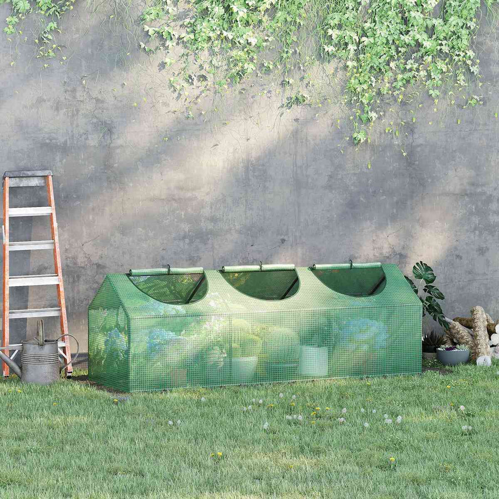 Mini-serre verte garnie de pots contre un mur au jardin