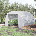 Serre tunnel blanche avec cultures près d’un potager