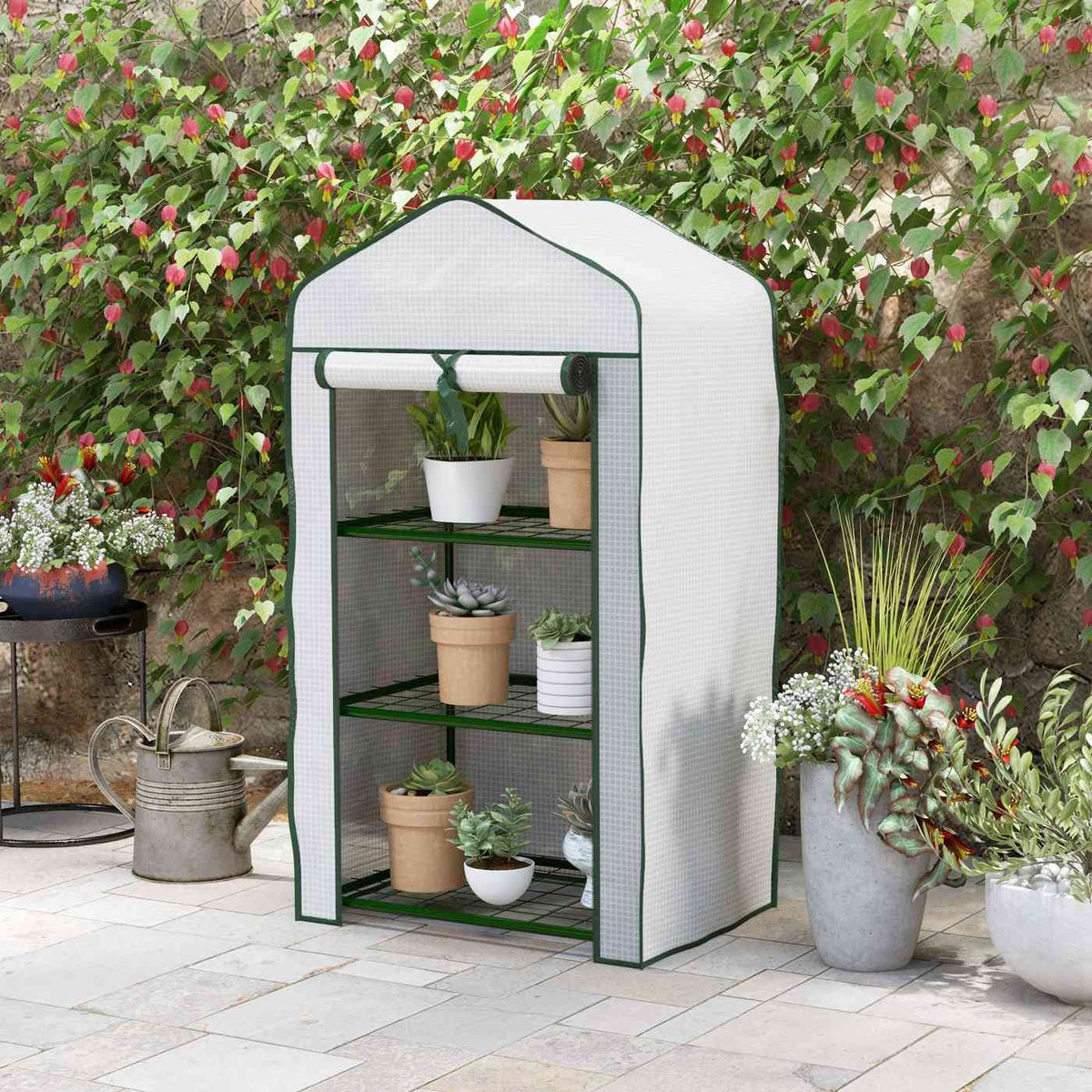 Mini serre blanche avec plantes devant des fleurs