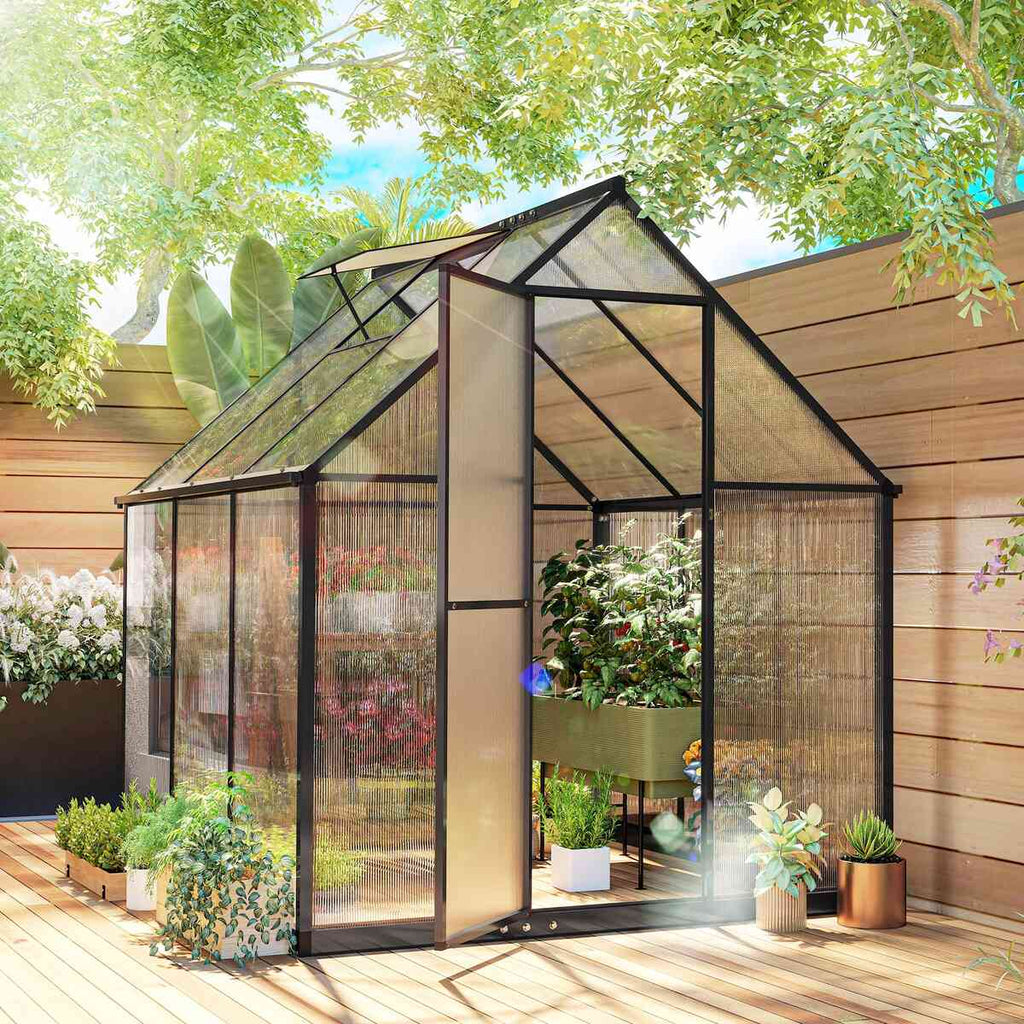 Serre noire à porte ouverte avec plantes sur une terrasse en bois