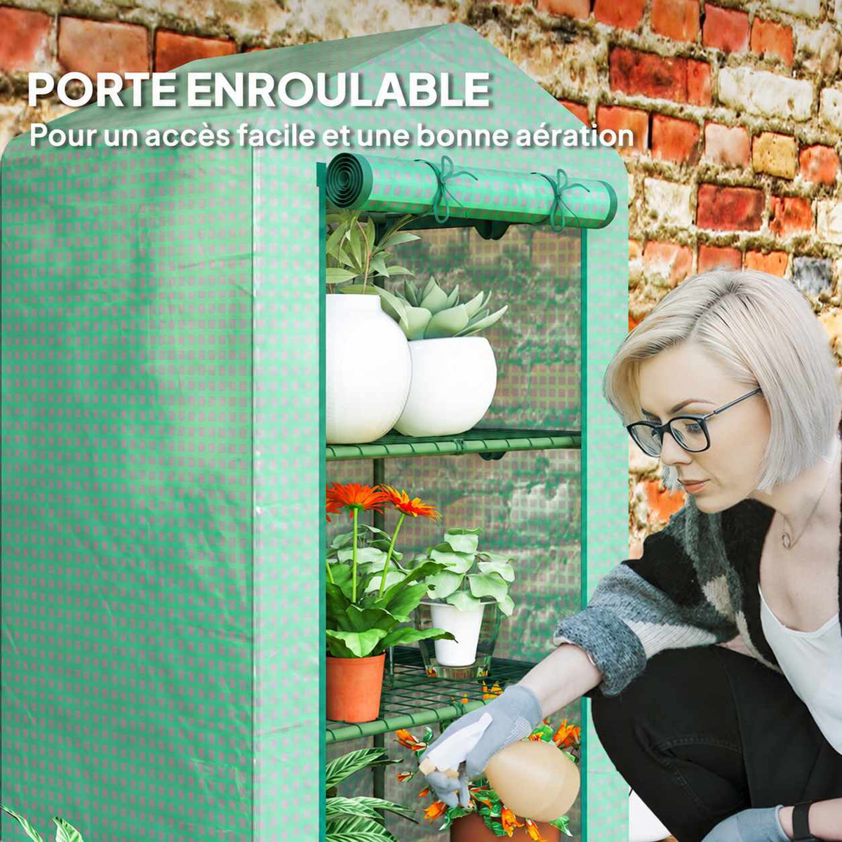 Femme entretenant les plantes par la porte ouverte de la mini serre verte