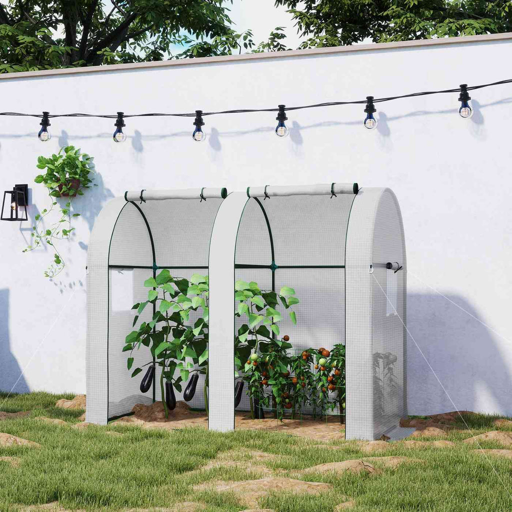 Serre blanche à deux portes ouvertes avec légumes contre un mur blanc