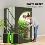 Femme entretenant les plantes par la porte zippée de la chambre de culture