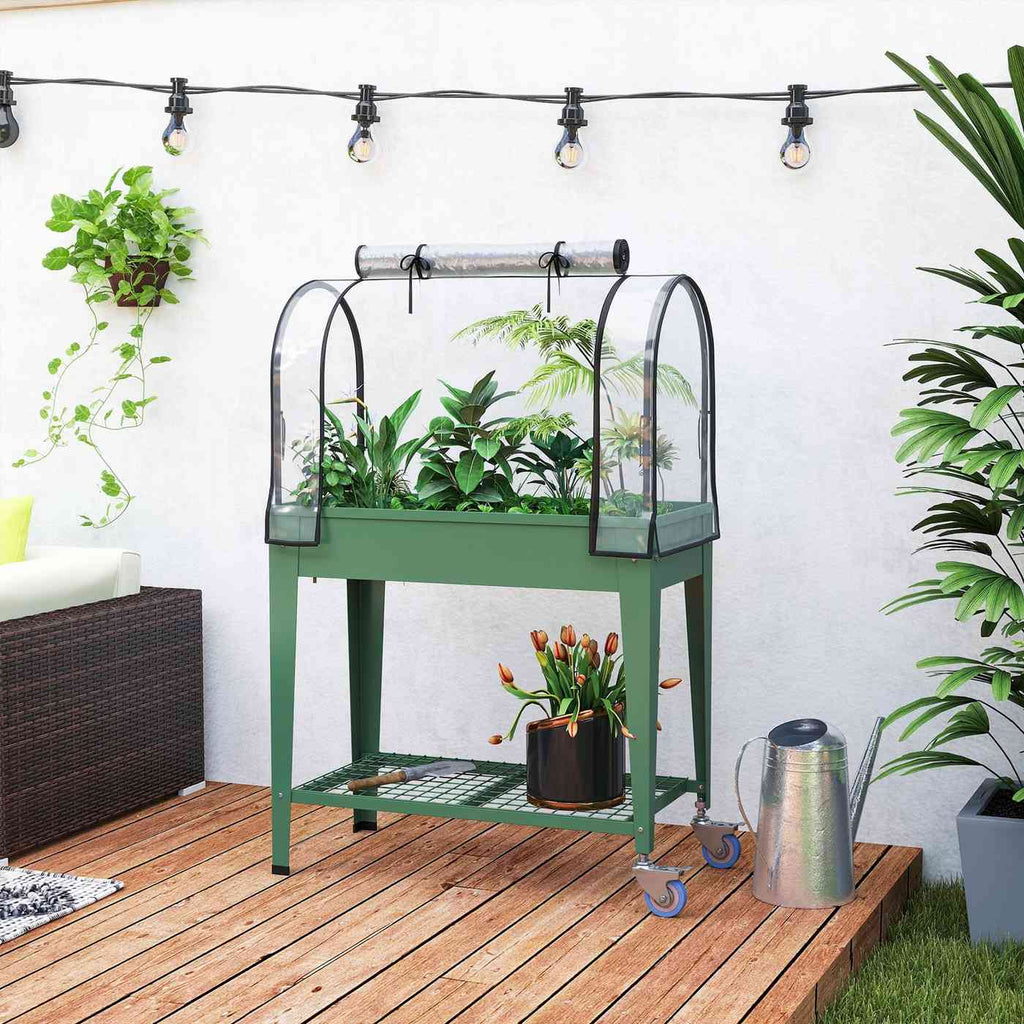 Bac potager vert avec serre, plantes et roulettes sur une terrasse en bois