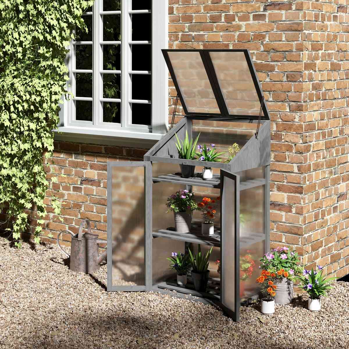 Armoire serre grise ouverte avec plantes contre un mur
