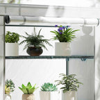 Gros plan sur les plantes et la porte enroulée de la serre de balcon blanche