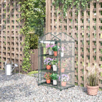 Mini serre transparente fleurie devant un treillage