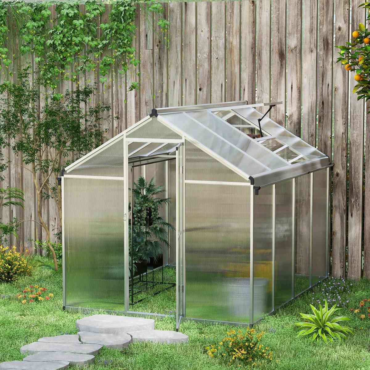 Serre en polycarbonate installée près d’une clôture en bois