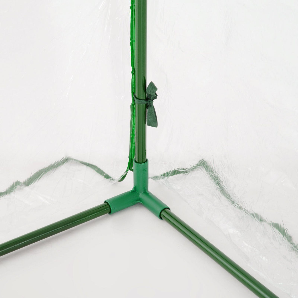 Gros plan d’un raccord vert à la base de la mini serre