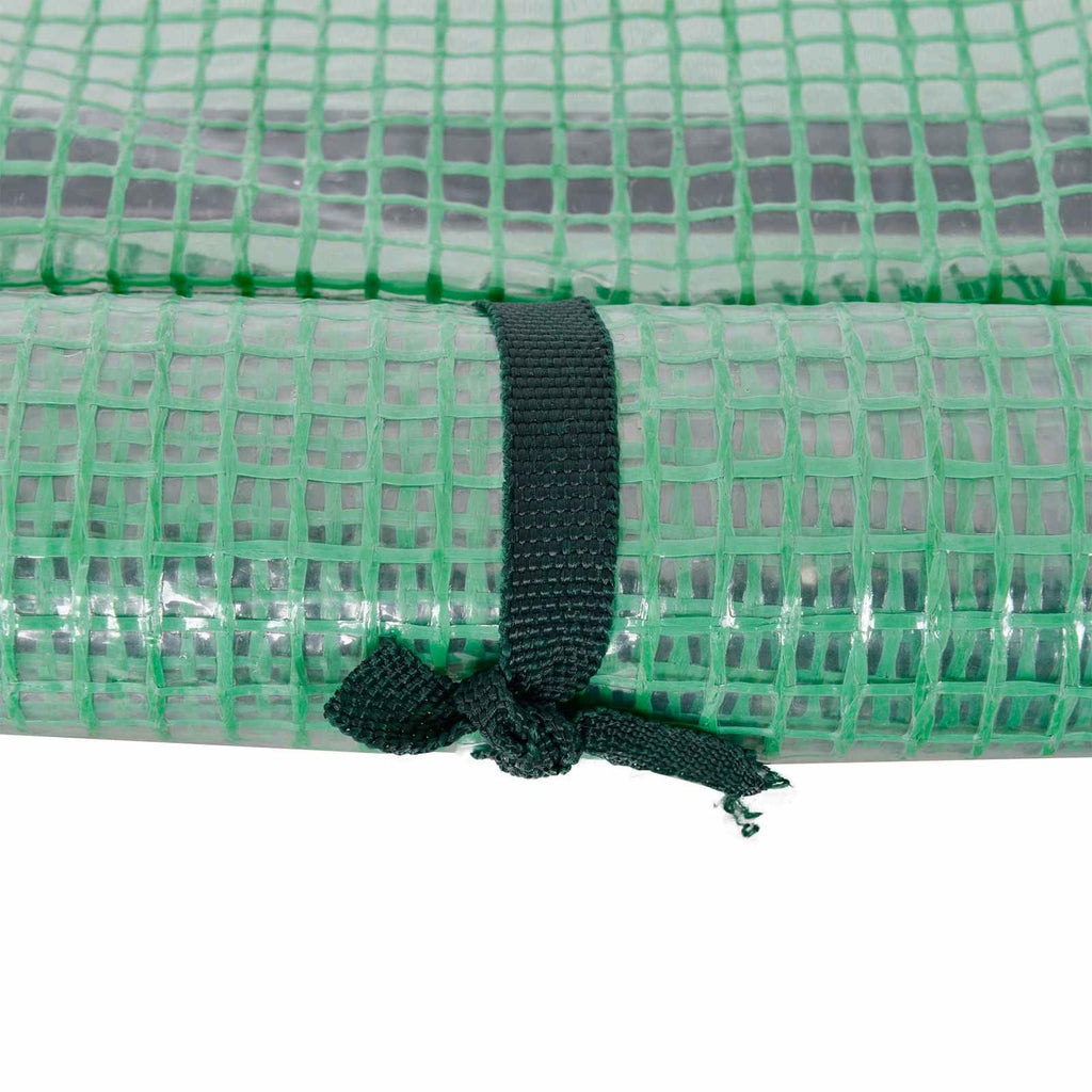 Attache nouée maintenant la porte de la mini-serre verte enroulée