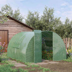 Serre tunnel verte avec plantes devant un abri de jardin