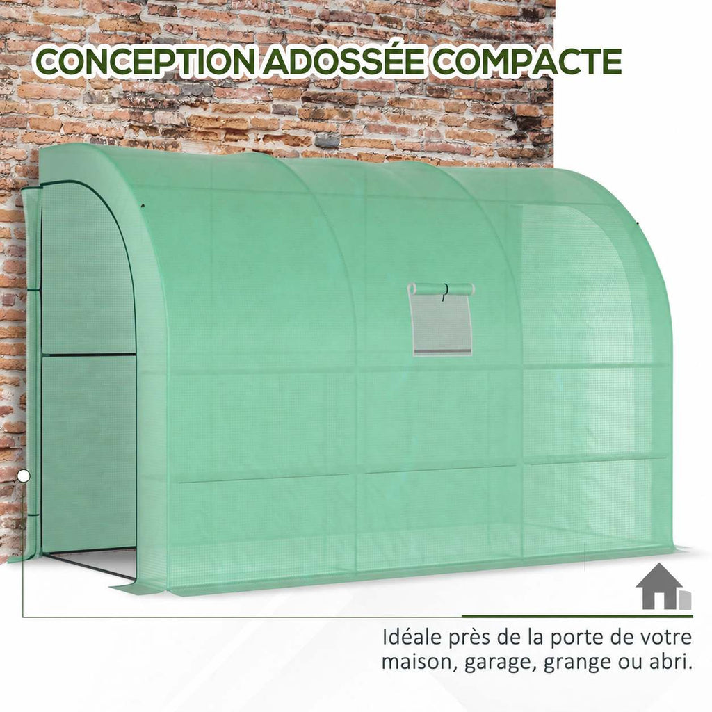 Serre adossée verte installée contre un mur en briques