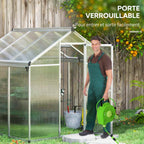 Jardinier avec arrosoir devant la porte ouverte de la serre