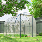 Serre tunnel transparente sur une pelouse près d’une clôture