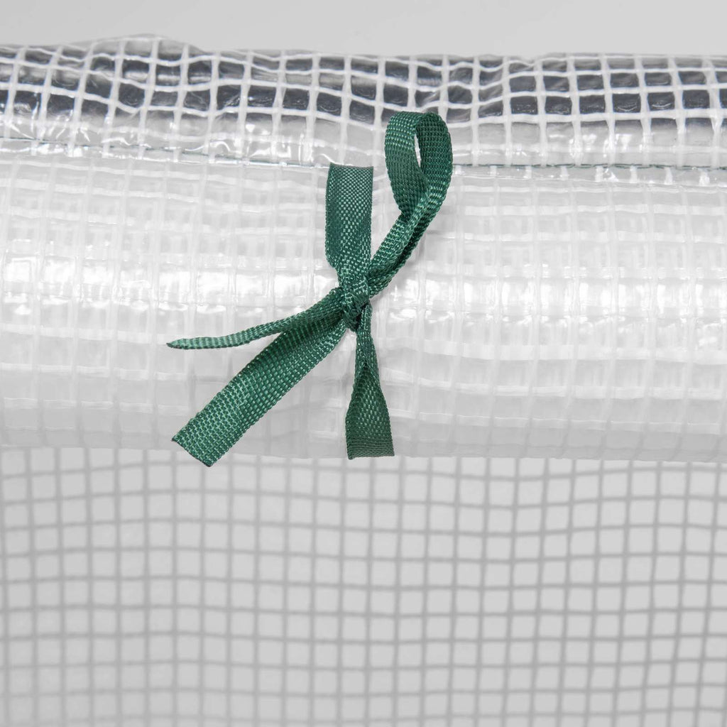 Attache verte maintenant une porte de la mini-serre blanche enroulée