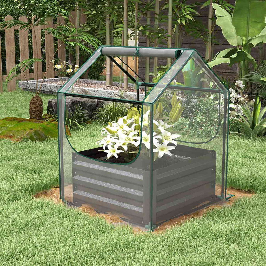 Carré potager gris avec housse transparente et fleurs blanches dans le jardin