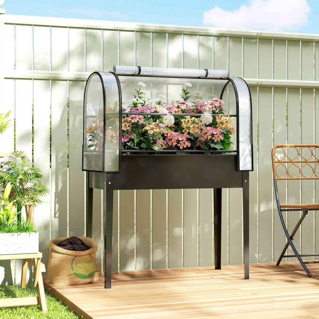 Bac potager surélevé noir et fleurs roses sur une terrasse en bois