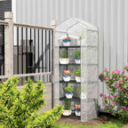 Mini serre transparente remplie de plantes près d’une terrasse