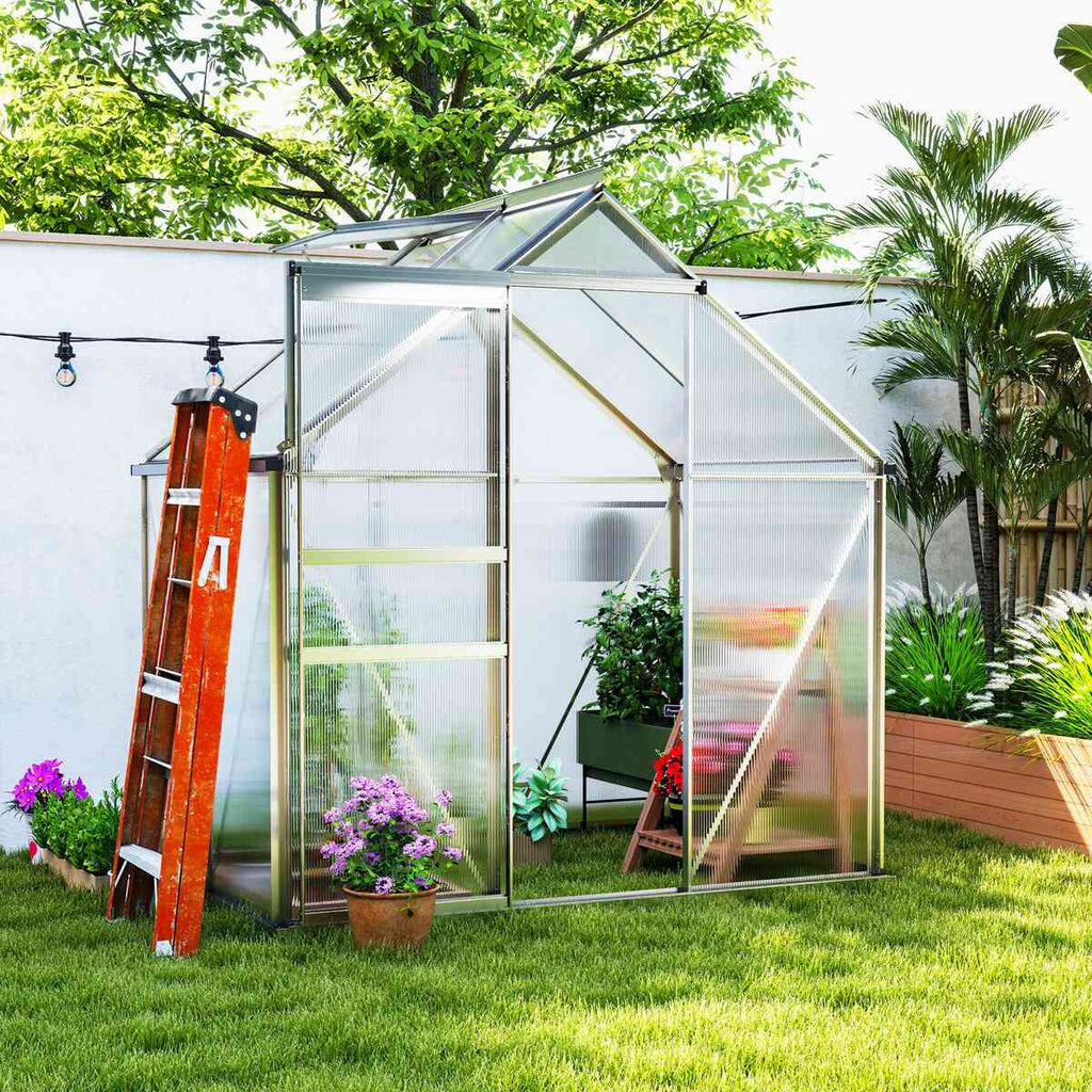 Serre argentée dans un jardin, avec échelle et fleurs à proximité