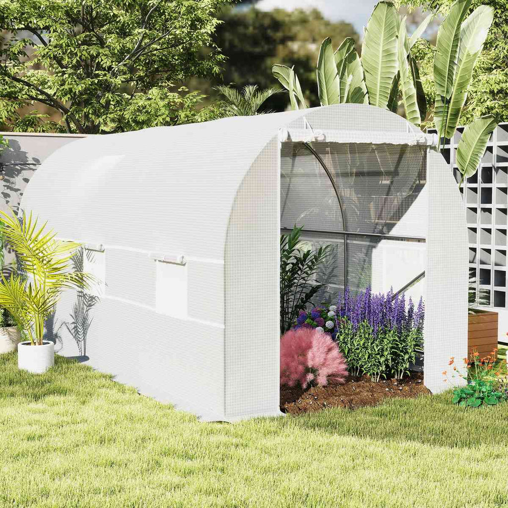 Serre tunnel blanche garnie de plantes fleuries au jardin