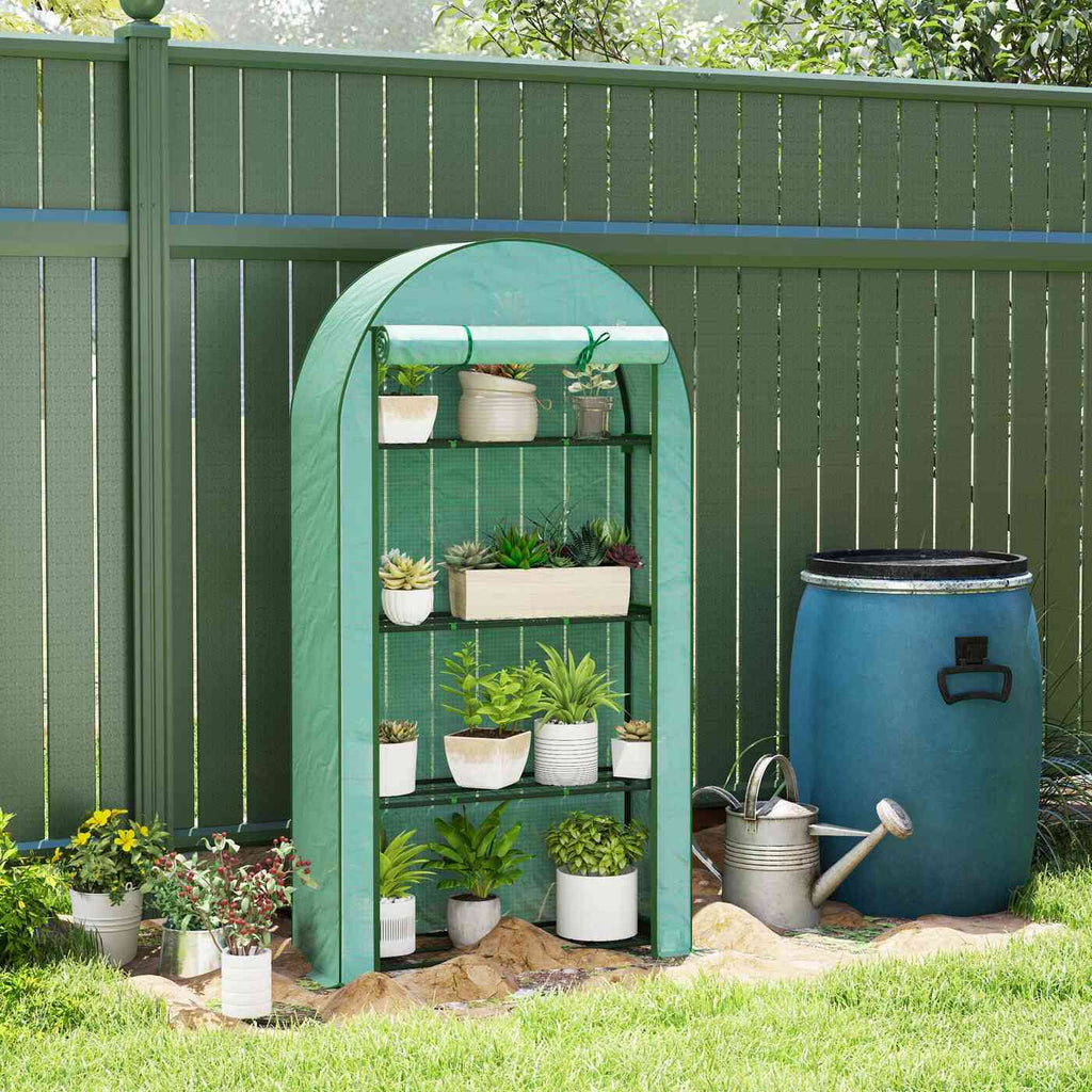 Serre de balcon verte avec plantes devant une clôture et un récupérateur d’eau